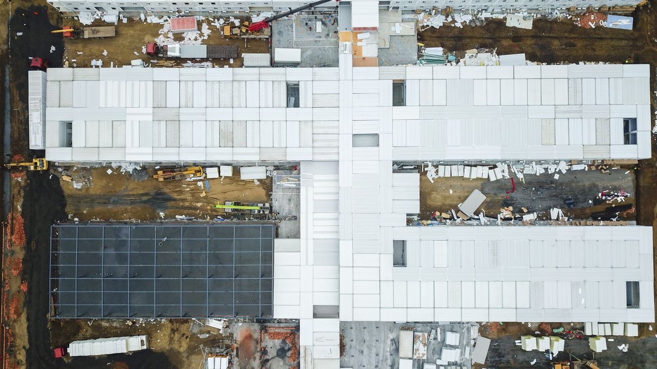 services-03 Drone shot capturing aerial view of a large construction site with unfinished buildings.