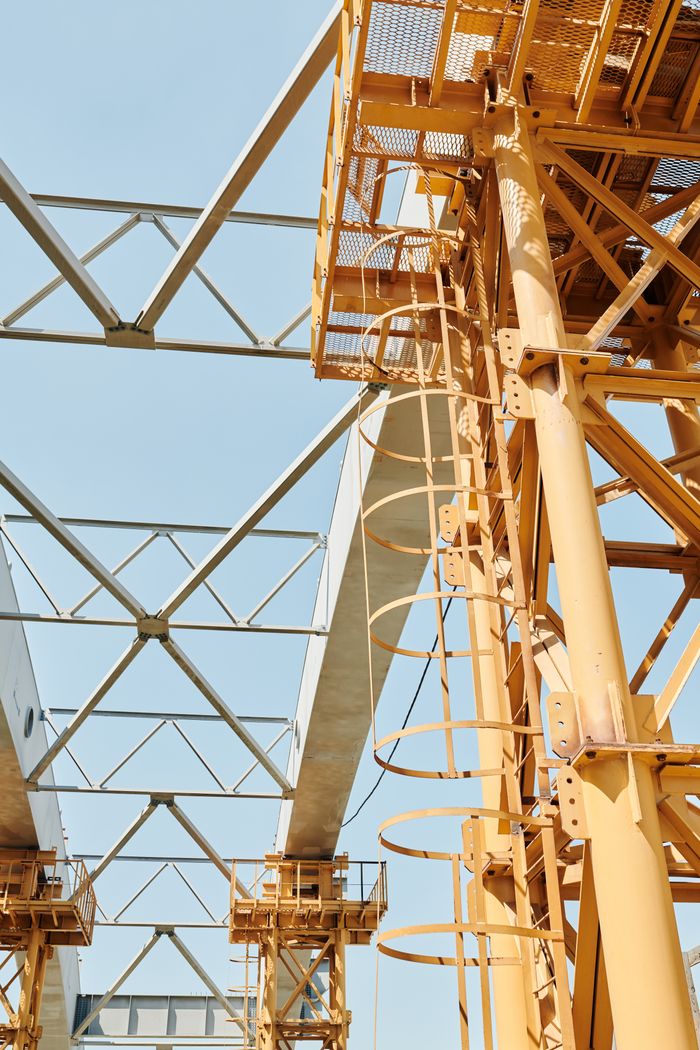 who-we-are Steel structures and scaffolding on a clear day at a construction site.